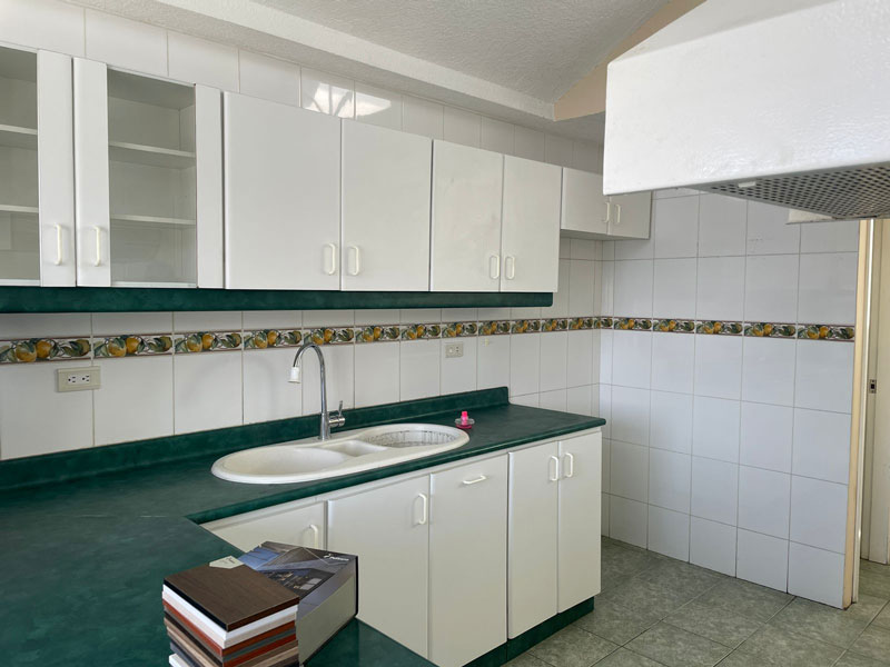 Cocina con gabinetes blancos, y mesón verde Remodelación de Cocina Fainsa