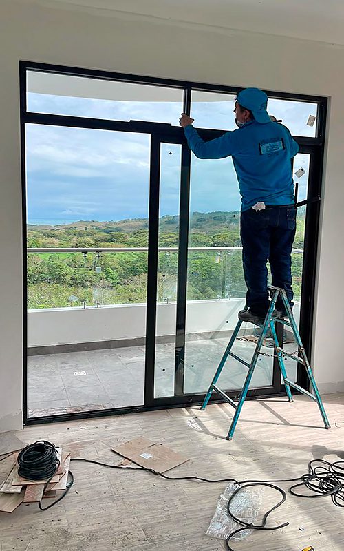 Trabajador de Fainsa instalando ventanas de aluminio color negro T45